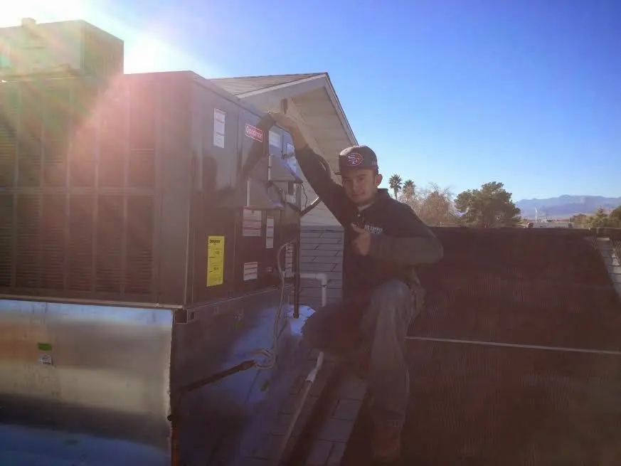 HVAC technician performing Air Duct Repair on a rooftop unit in La Habra Heights